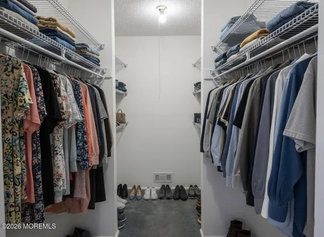 a view of walk in closet with clothes and shoes