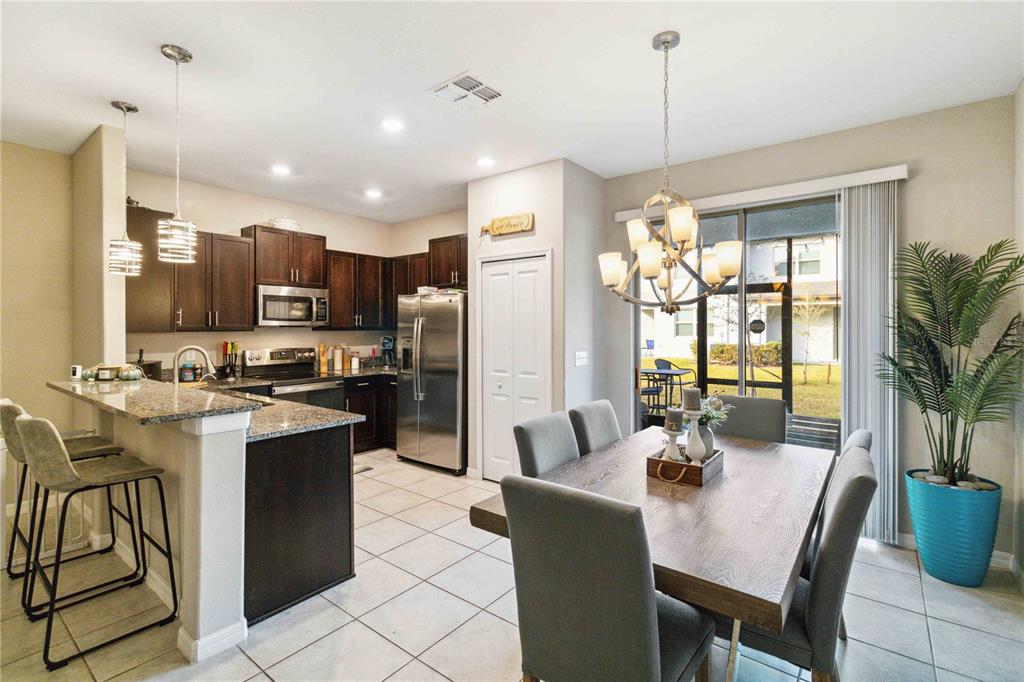 14339 Easy Goer Street Ruskin, FL 33573 - Photo 13 of 49 a kitchen with a refrigerator a stove a sink dishwasher with a dining table and chairs