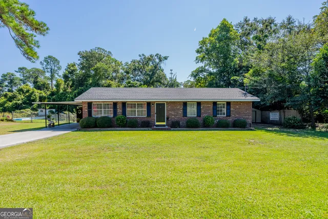 a front view of a house with yard and green space