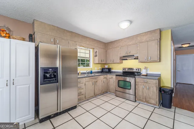 a kitchen with stainless steel appliances granite countertop a refrigerator and a stove top oven