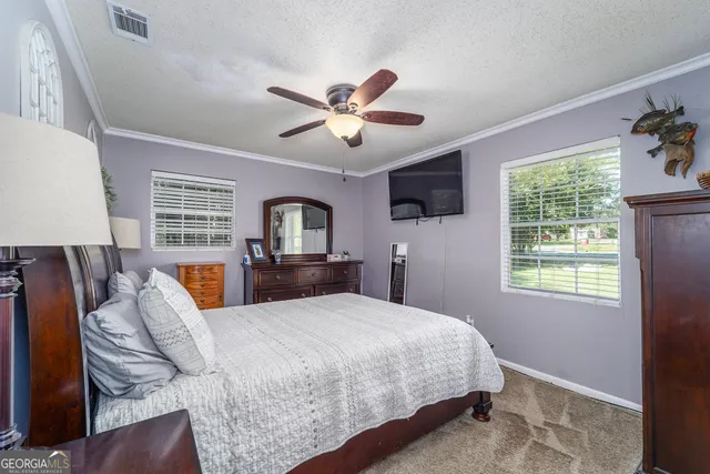 a bedroom with a large bed and a chandelier