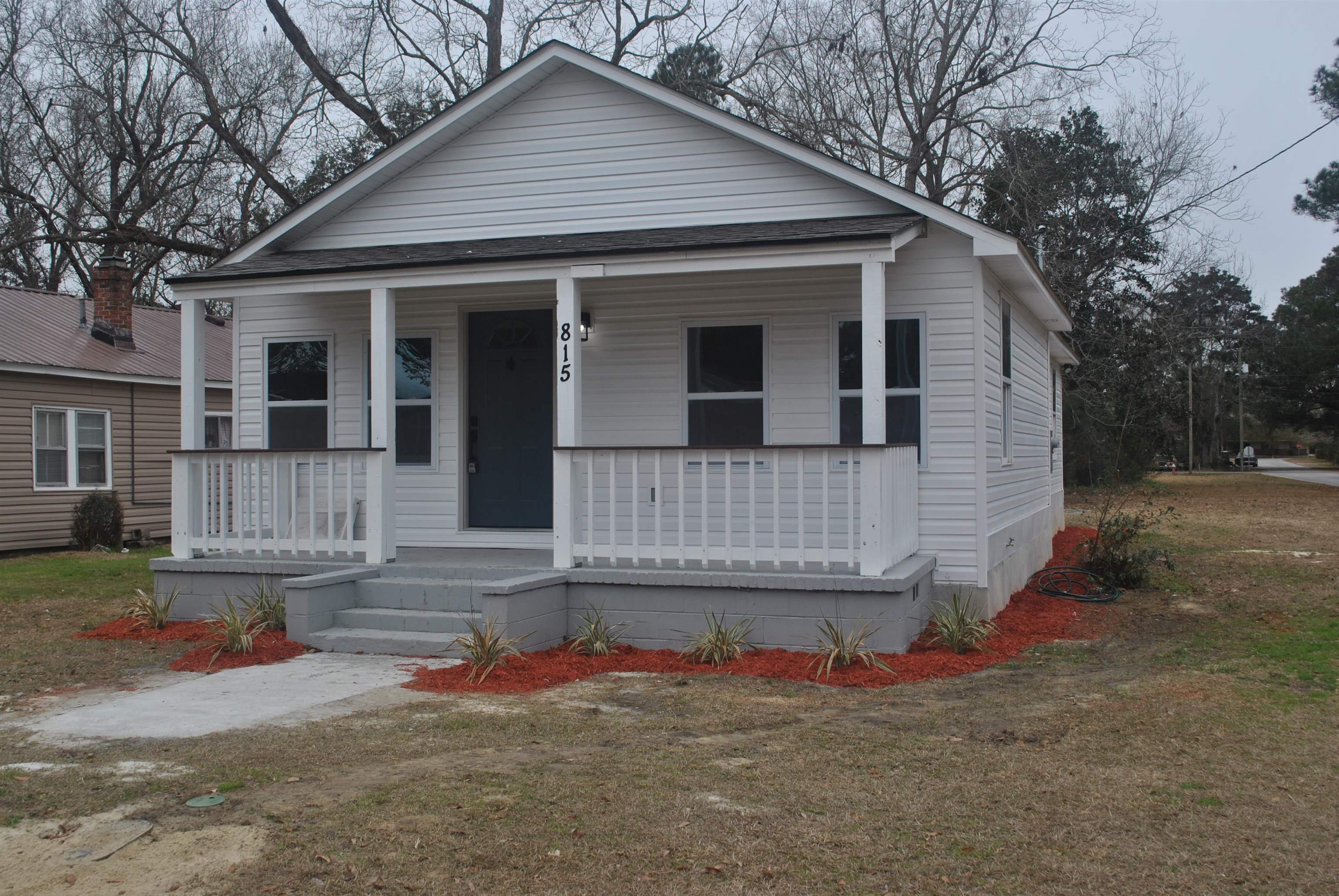 Bungalow-style home featuring covered porch and a front lawn