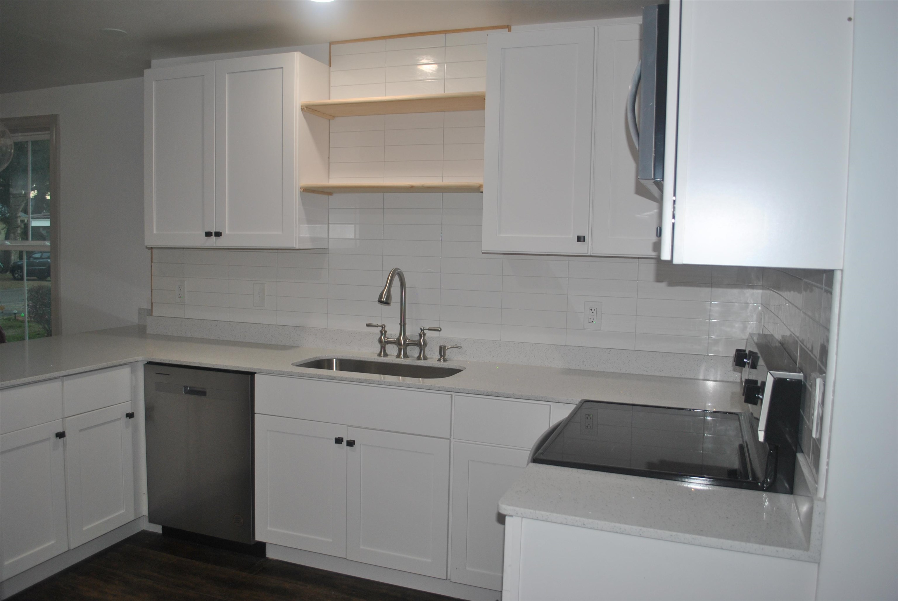 815 North Congdon Street Georgetown, SC 29440 - Photo 11 of 28 Kitchen with stainless steel appliances, white cabinetry, decorative backsplash, and light stone counters