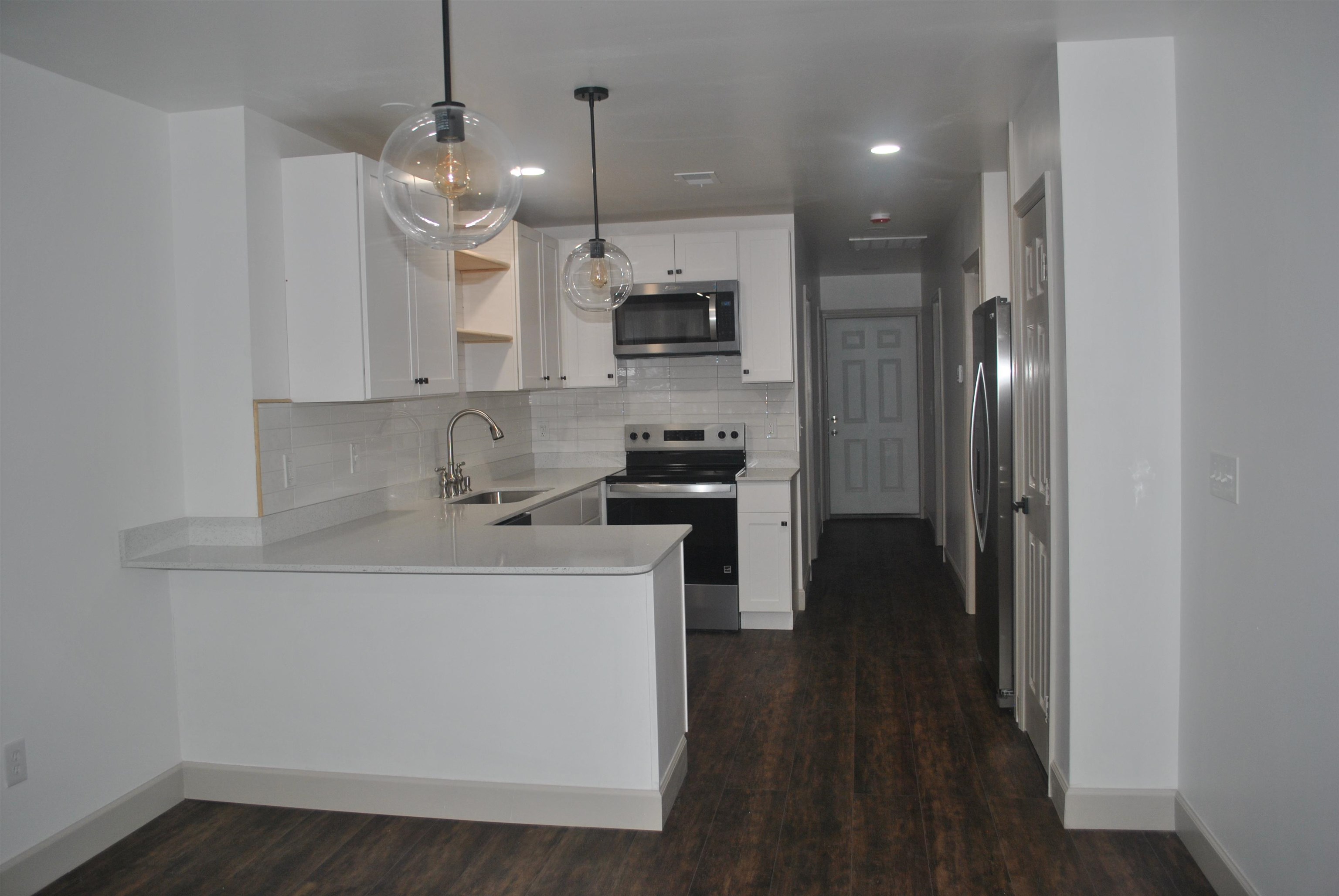 815 North Congdon Street Georgetown, SC 29440 - Photo 8 of 28 Kitchen featuring a peninsula, appliances with stainless steel finishes, decorative light fixtures, tasteful backsplash, and white cabinetry