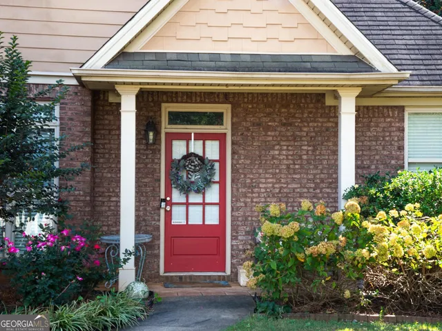 a front view of a house with a lots of flower plants