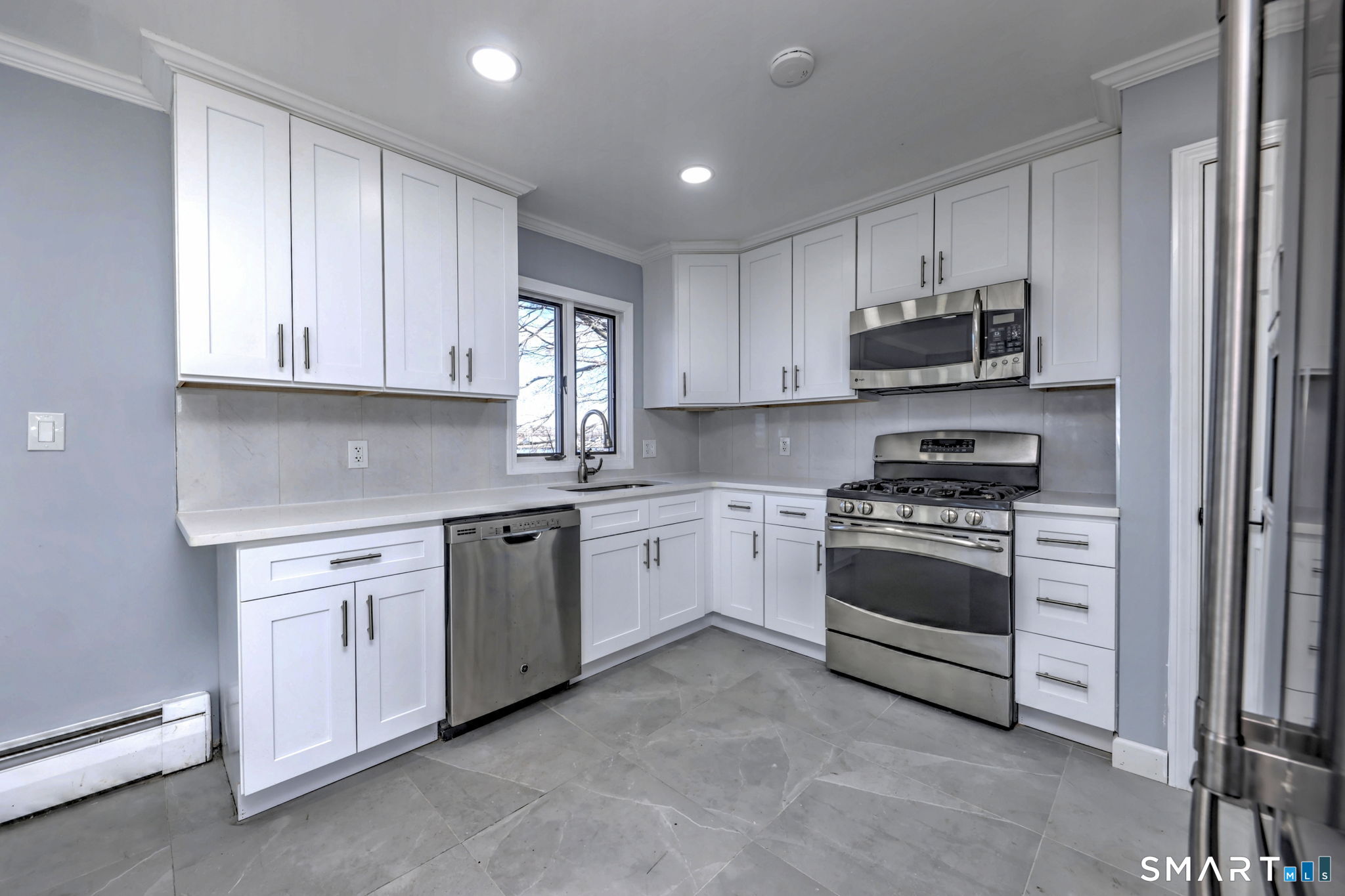 206 Bridgeview Place Stratford, CT 06614 - Photo 14 of 34 a kitchen with stainless steel appliances granite countertop a stove and white cabinets
