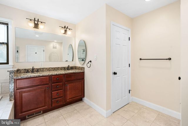 a spacious bathroom with a granite countertop sink and a mirror