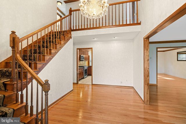 a view of staircase with lots of frames on wall and wooden floor