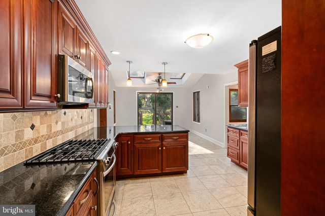 a kitchen with stainless steel appliances granite countertop a refrigerator and a stove