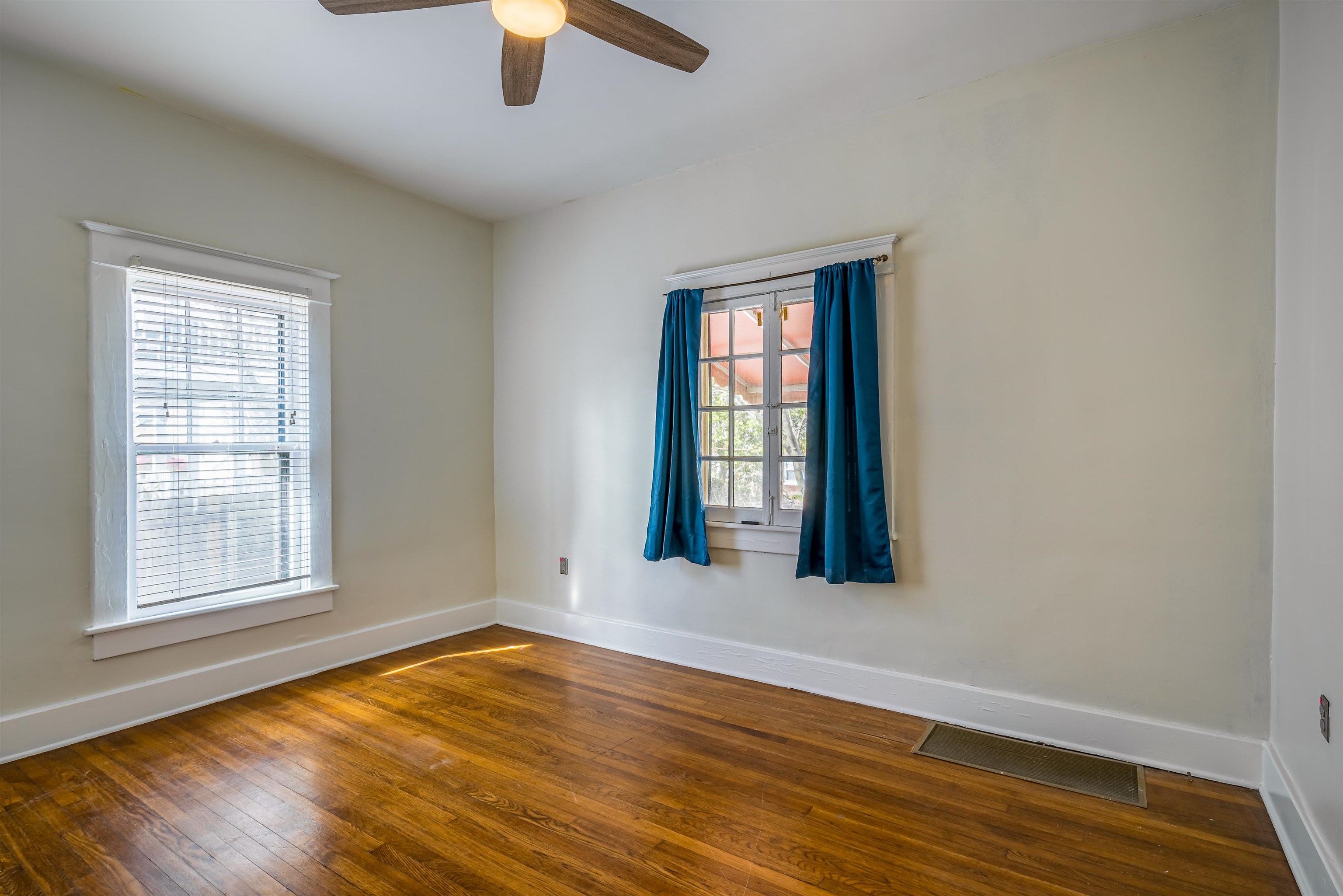 1997 Harbert Avenue Memphis, TN 38104 - Photo 12 of 23 an empty room with wooden floor chandelier fan and windows