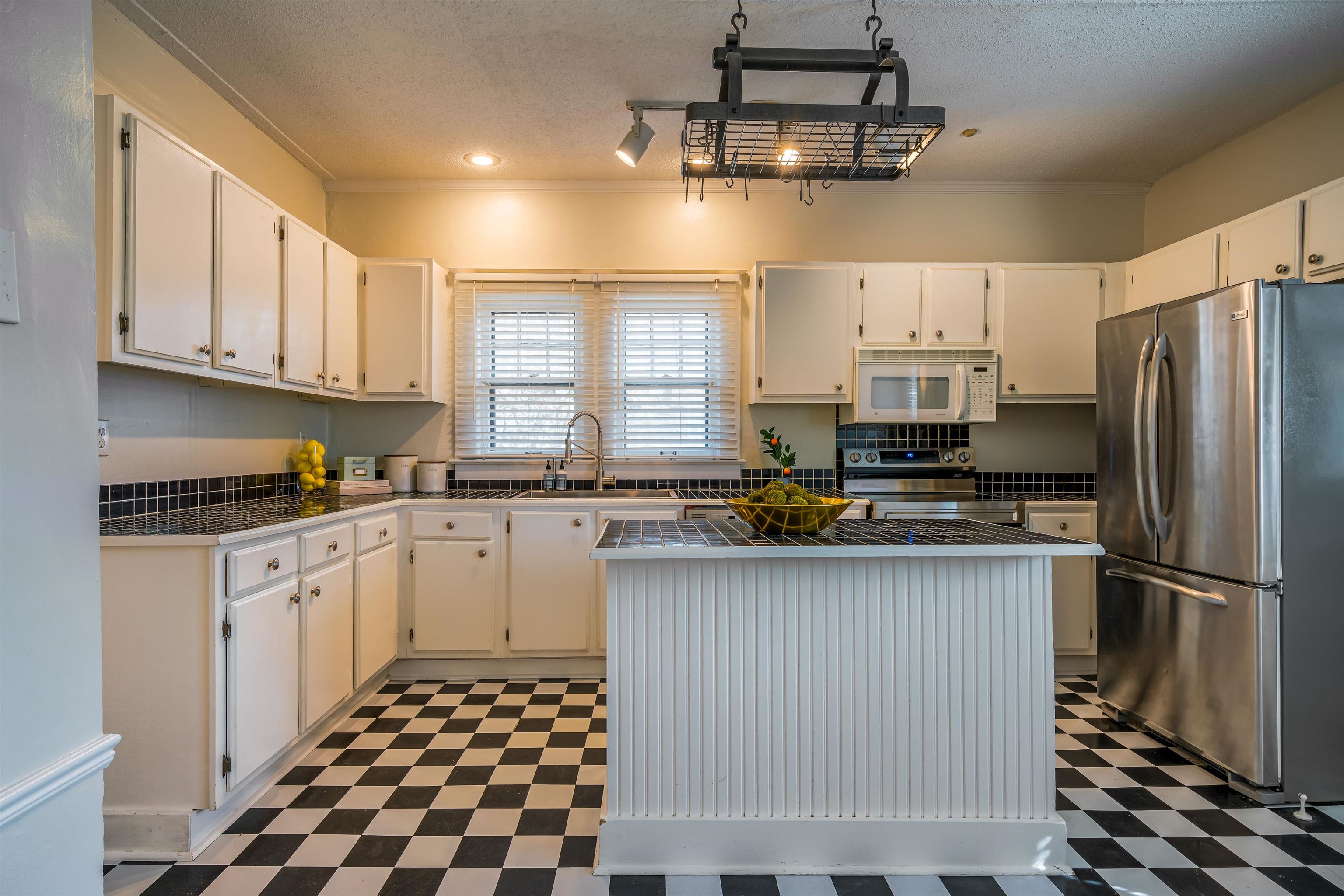 1997 Harbert Avenue Memphis, TN 38104 - Photo 8 of 23 a kitchen with stainless steel appliances granite countertop a refrigerator a sink dishwasher a stove and white cabinets