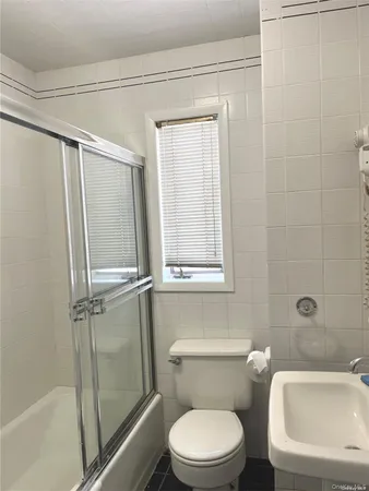 a white toilet sitting next to a bath tub