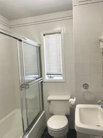 a white toilet sitting next to a bath tub