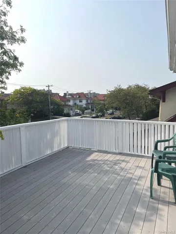 a view of a balcony with wooden floor and fence