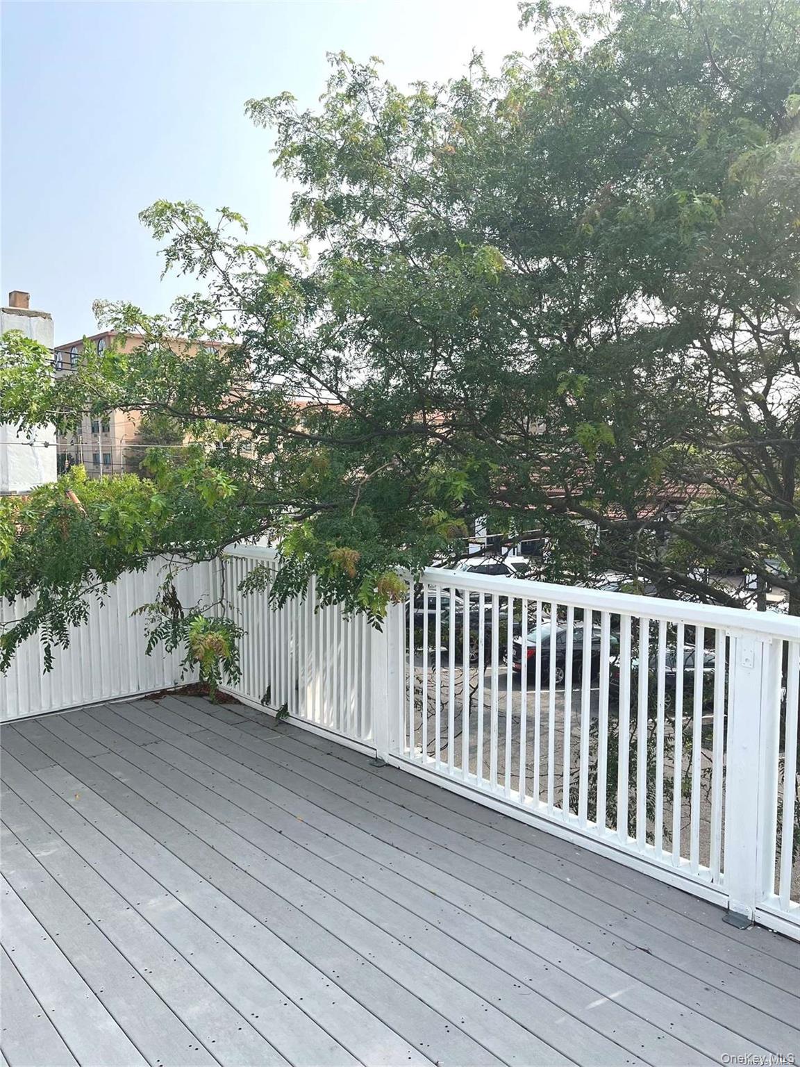 307 Magnolia Boulevard, Unit UPPR Long Beach, NY 11561 - Photo 17 of 17 a balcony with wooden floor