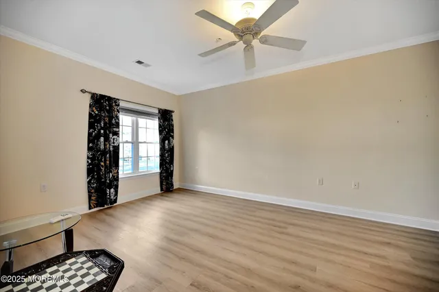 a view of a livingroom with a hardwood floor and a ceiling fan
