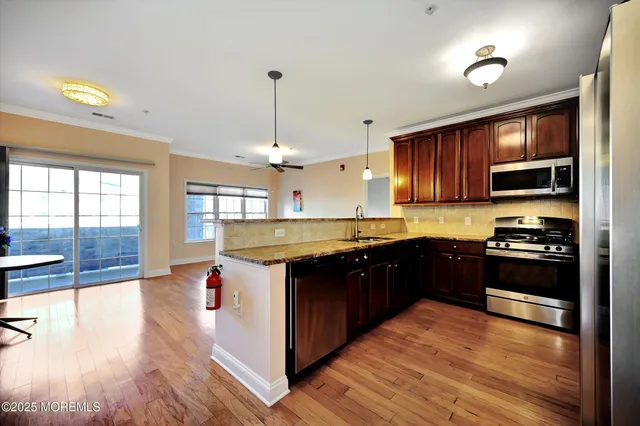 a kitchen with granite countertop a sink cabinets and wooden floor