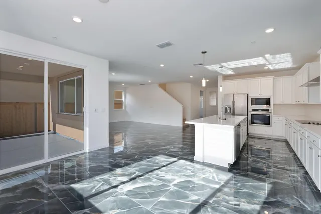 a large kitchen with cabinets and wooden floor