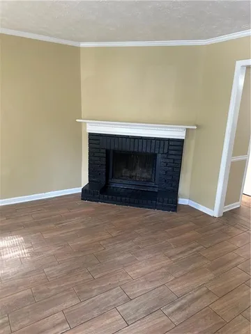 a view of empty room with wooden floor and fireplace