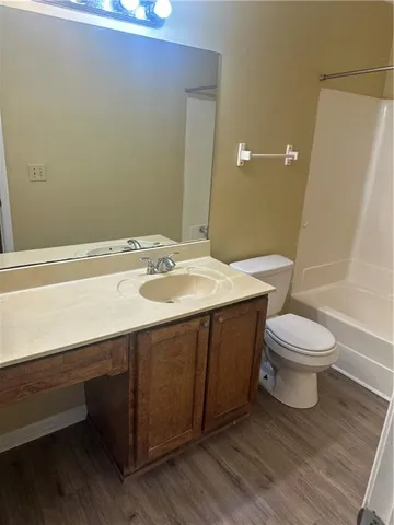 a bathroom with a sink a toilet a mirror and shower