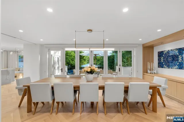 a dining room with furniture large windows and a chandelier