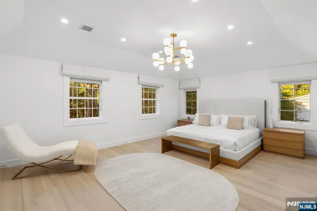 a spacious bedroom with two beds and a chandelier