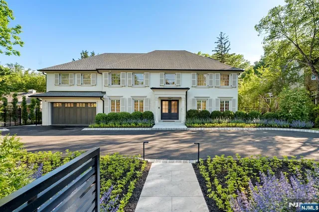 a front view of a house with a yard and potted plants
