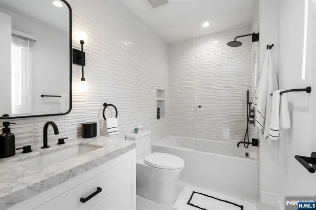 a bathroom with a granite countertop sink toilet and shower