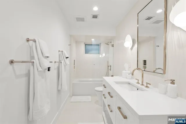 a bathroom with a double vanity sink mirror and a shower