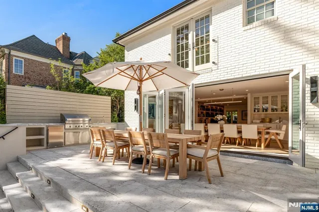 a view of a patio with table and chairs and floor to ceiling window
