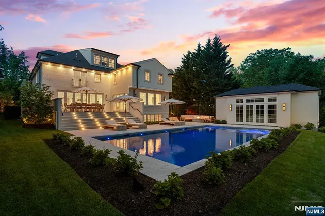 a view of a patio with a table and chairs under an umbrella with a small yard