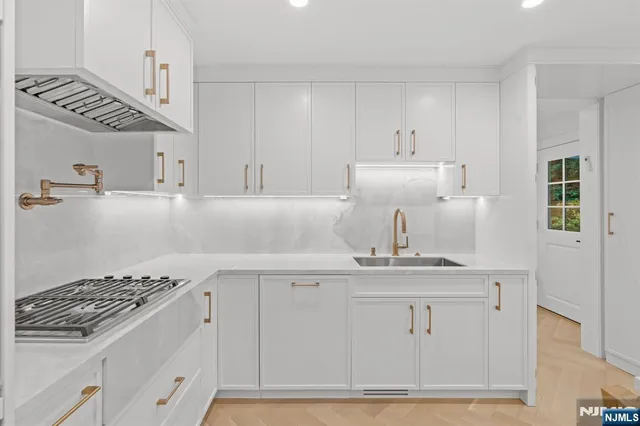 a kitchen with kitchen island a sink stove and cabinets