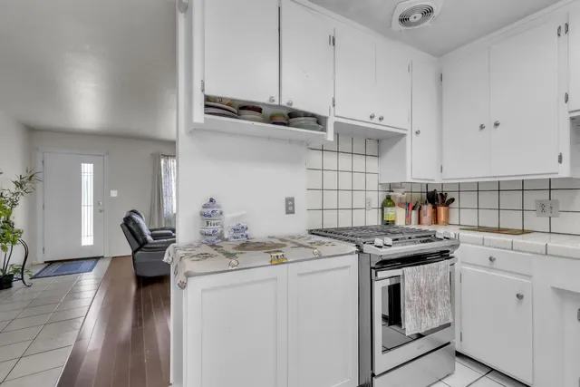 a kitchen with stainless steel appliances a stove a sink and cabinets