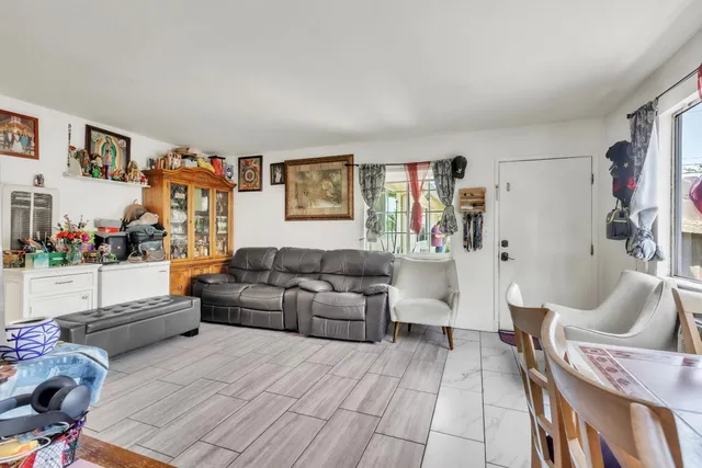 a living room with furniture and a painting on the wall