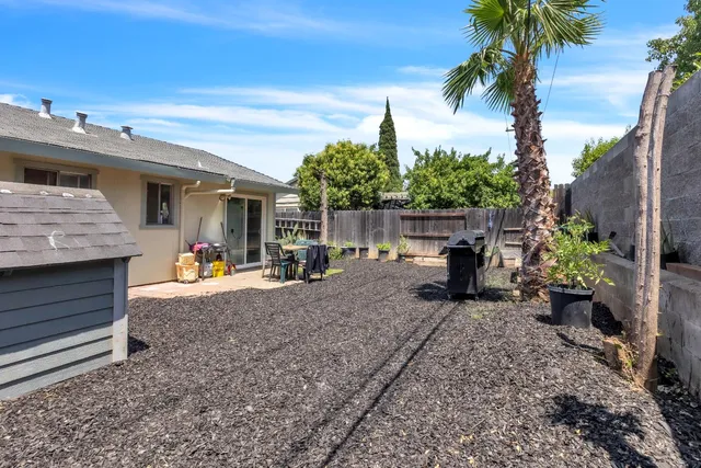 a view of a house with backyard and sitting area