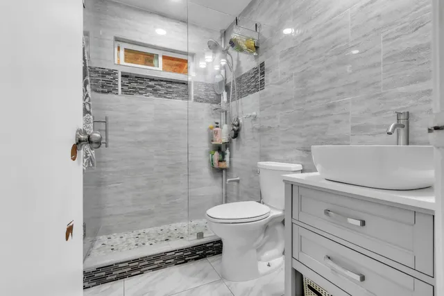 a bathroom with a sink a toilet and shower