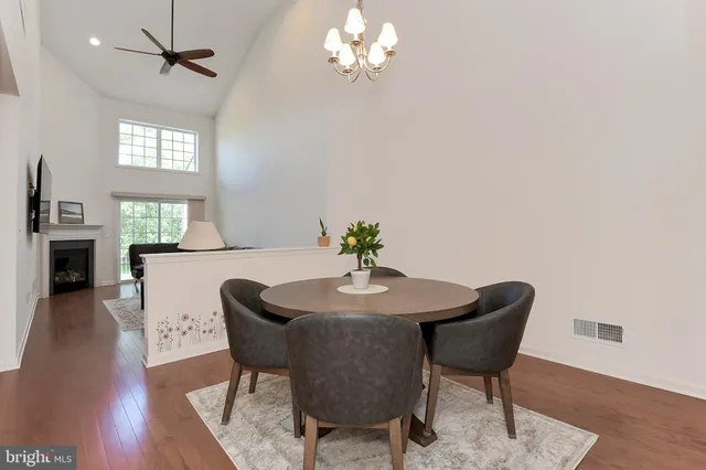a dining room with furniture a chandelier and wooden floor