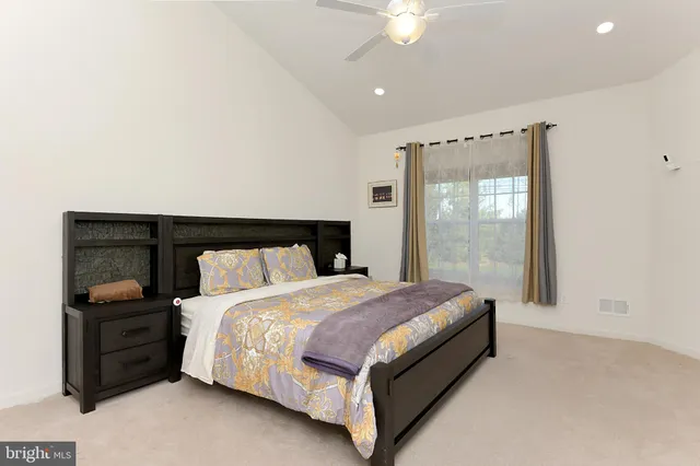 a bed sitting in a spacious bedroom next to a window