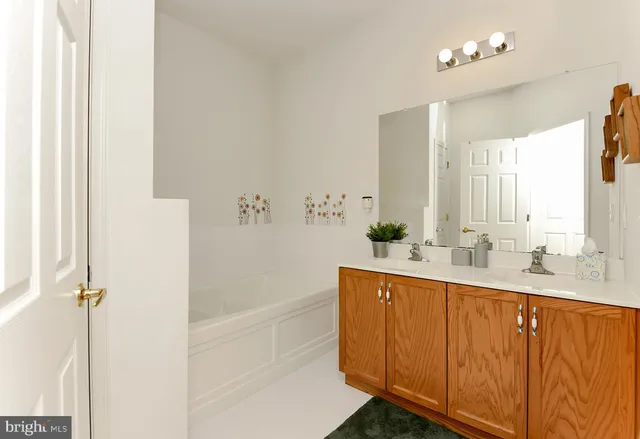a bathroom with a double vanity sink a mirror and a bathtub