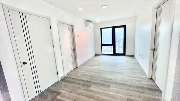 a view of a hallway with wooden floor and entryway
