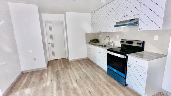 a kitchen with granite countertop a sink and a stove top oven