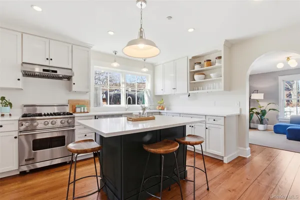 a kitchen with a stove a window and wooden cabinets