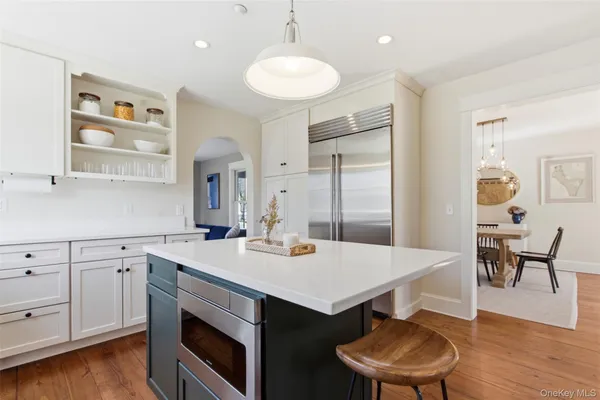 a kitchen with a sink a stove and chairs with wooden floor