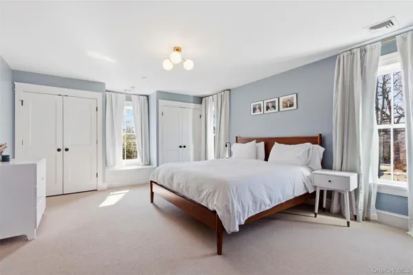 a spacious bedroom with a bed and a cabinets