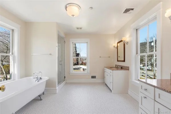 a bathroom with a tub sink and mirror