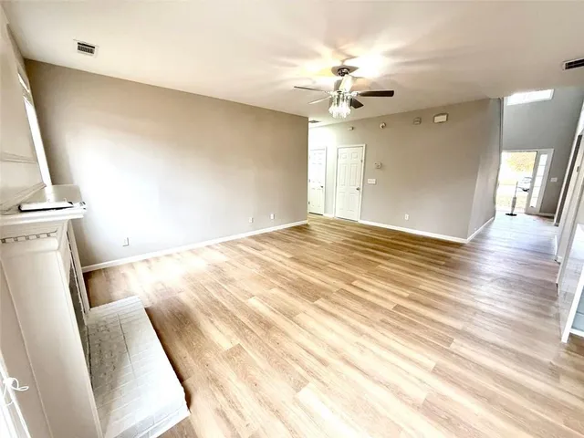 a large kitchen with stainless steel appliances kitchen island granite countertop a stove top oven a sink dishwasher and white cabinets with wooden floor