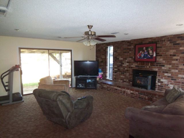 1140 Harpole Road Redding, CA 96002 - Photo 3 of 15 a living room with furniture a flat screen tv and a fireplace