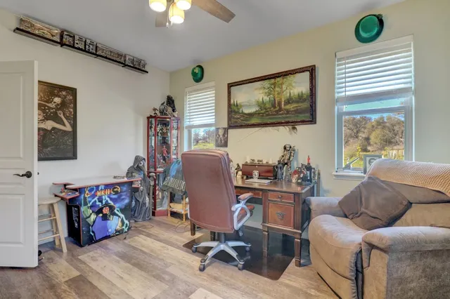 a kitchen with stainless steel appliances granite countertop a stove refrigerator a dining table and chairs with wooden floor