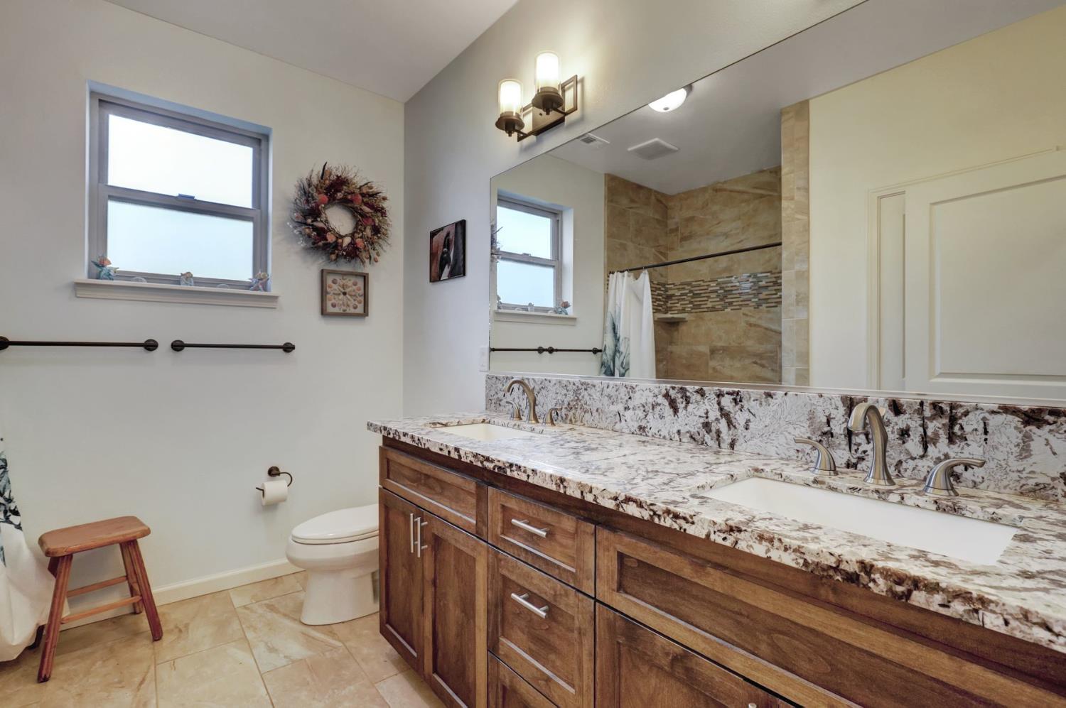 6718 Cross Star Trail Loma Rica, CA 95901 - Photo 16 of 54 a bathroom with a granite countertop sink a toilet and mirror