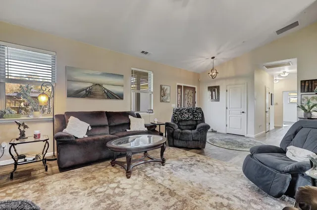 a kitchen with stainless steel appliances granite countertop a refrigerator a stove a sink a dining table and chairs